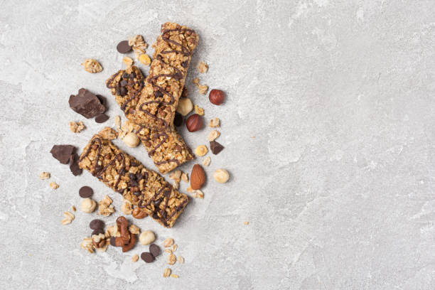 Top view of granola energy bar with mix of nuts Top view of granola energy bar with mix of nuts for healthy nutrition on gray concrete background with copy space granola stock pictures, royalty-free photos & images