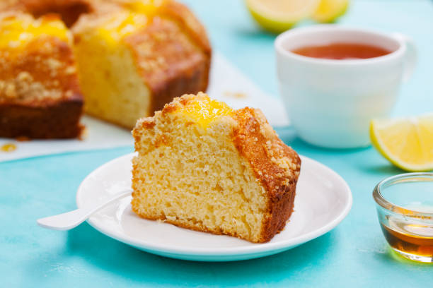 torta bundt al limone con tazza di tè. sfondo blu. da vicino. - tea cakes foto e immagini stock