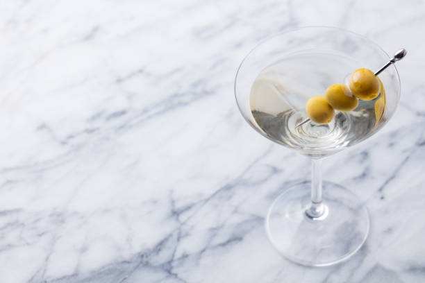 istock Martini cocktail with green olives on marble table background. Copy space. 1173502366