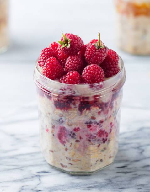 istock Overnight oats, bircher muesli with raspberry in a glass jar on marble background. Close up. 1173504276