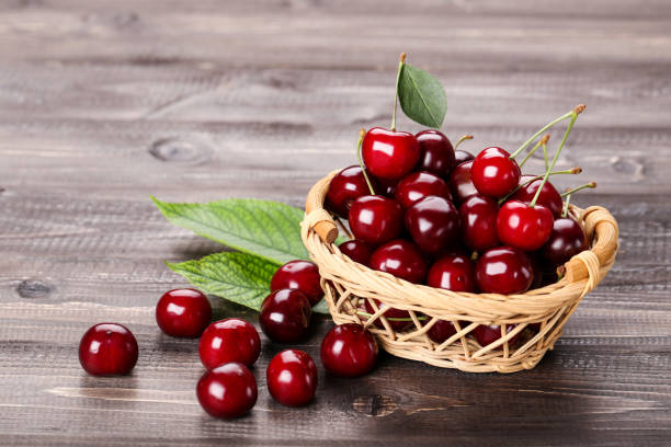 istock Sweet cherries with basket on wooden table 1173509313