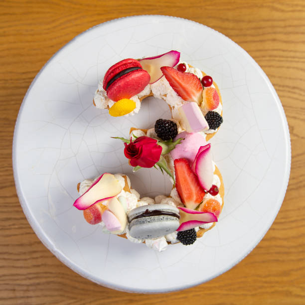 Abundantly decorated artisanal cake with candies and fruit in number 3 shape