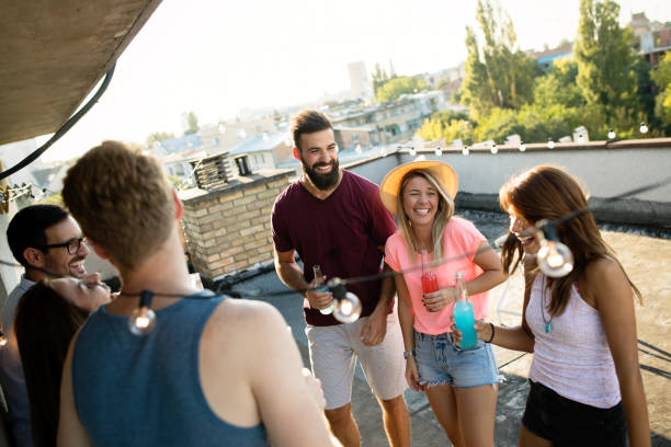 istock Young friends having fun at a rooftop party, playing the guitar, singing, dancing and drinking 1173515116