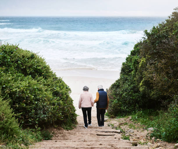 Rearview shot of a senior couple walking towards the beach