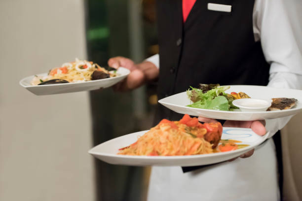 istock Waiter serving plates of food 1173520253