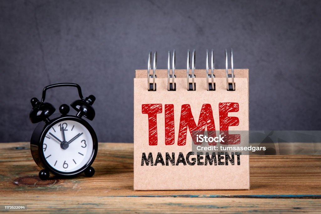 Time management concept Time management concept. Alarm clock and notebook on a wooden table Time Stock Photo