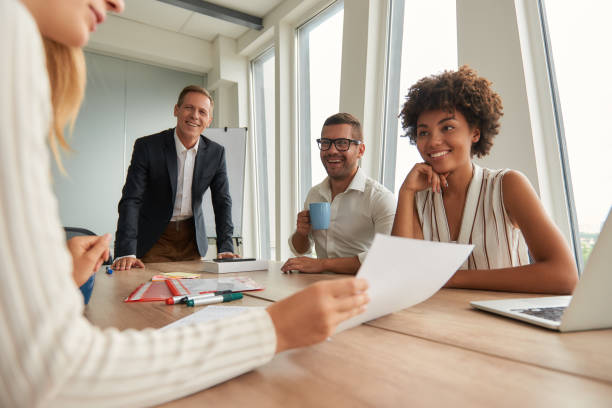 istock Multicultural team. Group of young business people looking at documents and discussing something while sitting at the office table 1173523622
