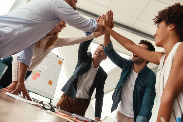 istock We did it! Business people giving each other high-five and smiling while working together in the modern office 1173523625