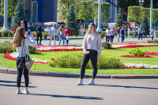 молодые привлекательные женщины фотографируются на фоне клумб - national landmark editorial color image horizontal стоковые фото и изображения