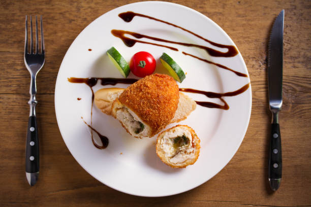 istock Chicken Kiev and vegetables on white plate, wooden background 1173524062