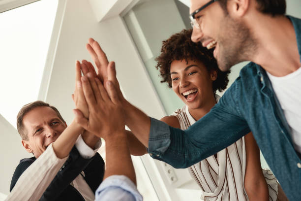 istock Celebrating success. Business people giving each other high-five and smiling while working together in the modern office 1173524441