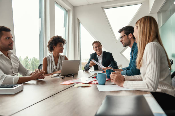 istock We have great results. Multicultural team discussing new project and smiling while sitting at the office table 1173524453