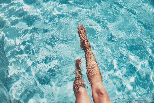 Beautiful womans legs in the pool Highangle view of beautiful legs in a splashing pool human leg photos stock pictures, royalty-free photos & images