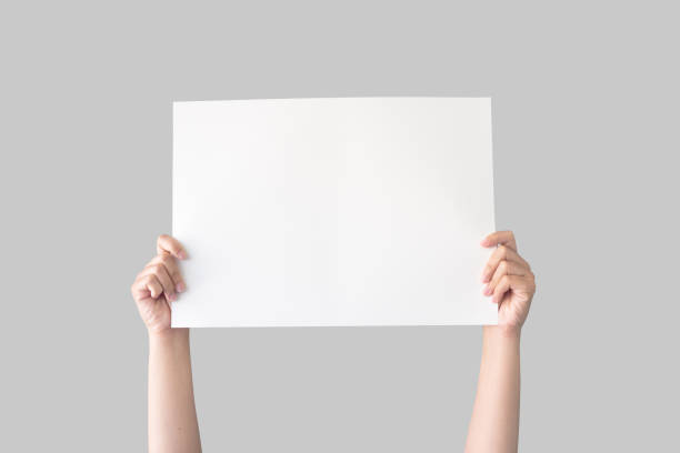 istock hand holding white blank paper isolated on grey background with clipping path 1173525083