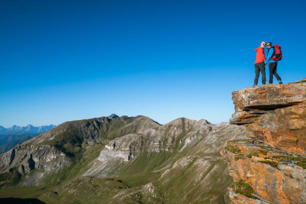 istock happy hiking couple on mountain summit at clear blue sky 1173526639