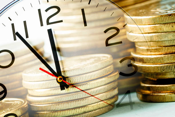istock Composite image of stacked gold coins and a clock 1173526642