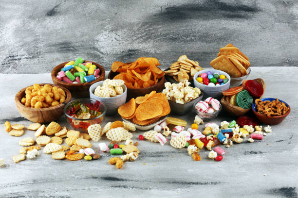 istock Salty snacks. Pretzels, chips, crackers and candy sweets on table 1173527626