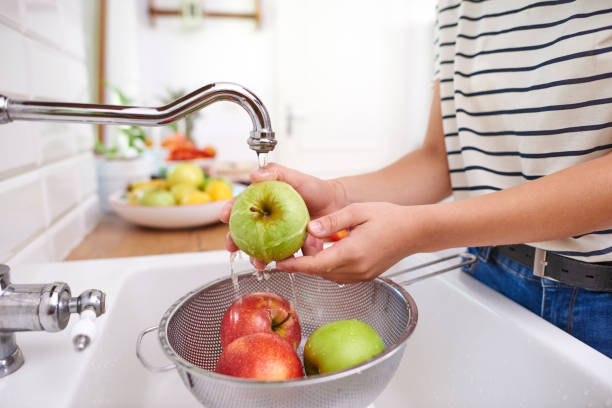 mujer lavando manzanas frescas de temporada - color image season people wet fotografías e imágenes de stock