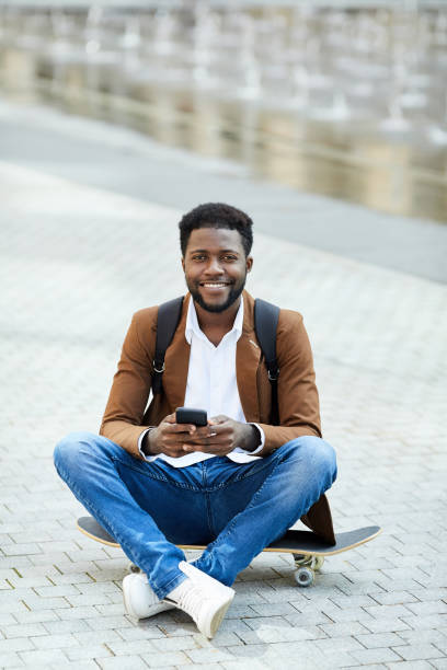 istock Smiling African-American Man Texting in City Square 1173529266