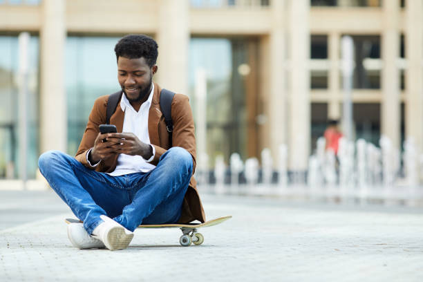 istock Young African-American Man Texting in City Square 1173529267