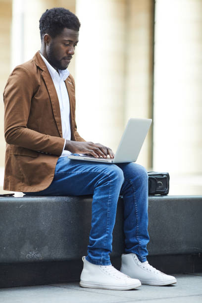 istock African-American Man using Laptop in City 1173529455