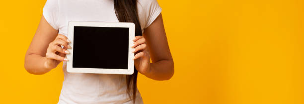 istock Unrecognizable Girl Showing Blank Tablet Screen Over Yellow Background, Cropped 1173530120