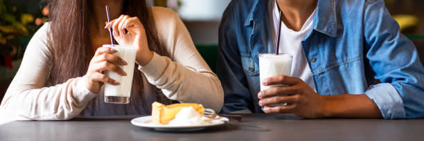 istock Two mixed race teens drinking milkshakes, eating cheesecake 1173530860