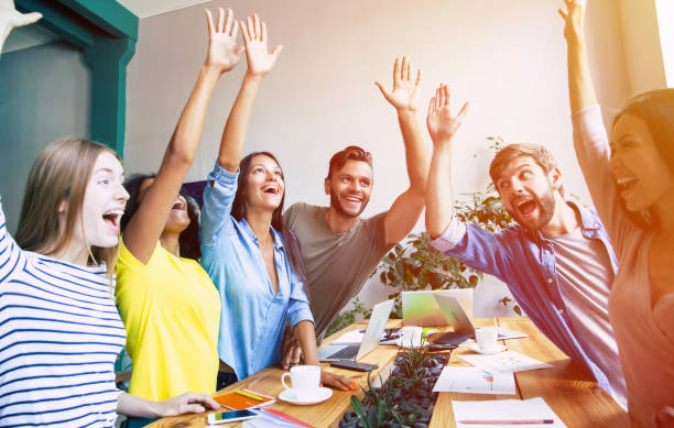 group of happy, excited and successful modern people in office. start up business team are holding hands together in circle. company of young students are celebrating some win. - hands clasped business education cooperation imagens e fotografias de stock