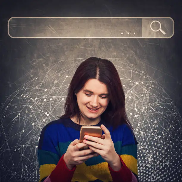 Photo of Curious woman using smartphone browsing network search bar with loupe to find useful information and data. Internet searching engines, modern technology and virtual life and networking concept.