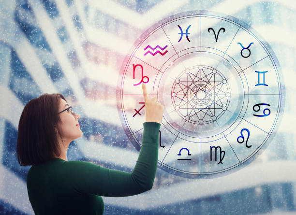 woman choosing a zodiac sign from the astrological wheel to find the future predictions. having trust in horoscope, consulting stars and believe in the power of universe. astrology esoteric concept. - trust imagens e fotografias de stock