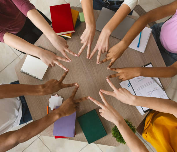 istock Multiracial students joining victory signs in circle, top view 1173535240