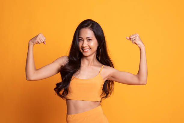 istock Beautiful young Asian woman flex bicep. 1173536439