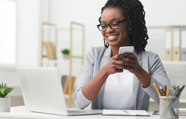 istock Afro Businesswoman Texting On Cellphone In Modern Office 1173539986