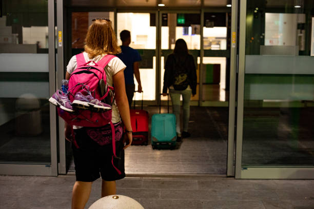 istock Young Woman Backpacker Entering Airport at Night 1173540970