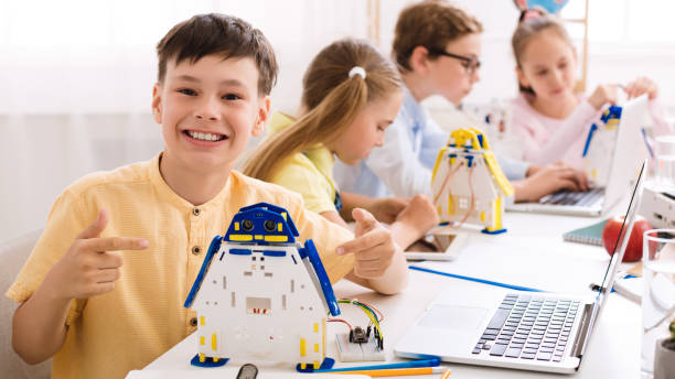 istock Happy schoolboy showing his robot, pointing with finger 1173544903