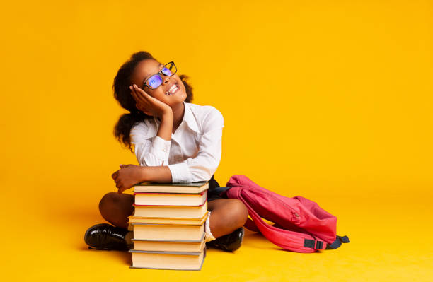 istock African American Elementary Student Girl Dreaming Sitting At Book Stack 1173544975