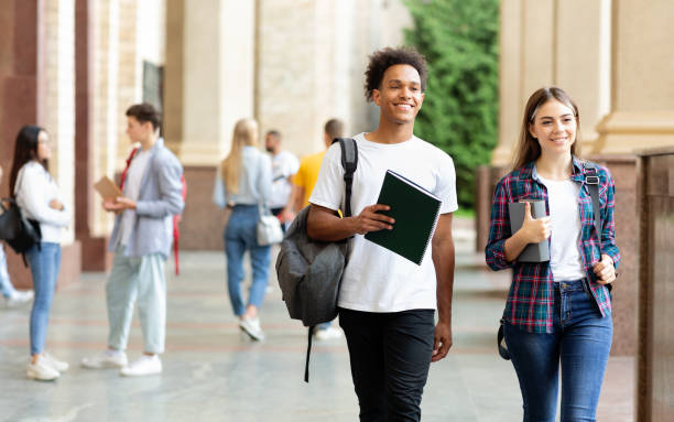 multiracial students walking in university hall outdoors - campus life imagens e fotografias de stock