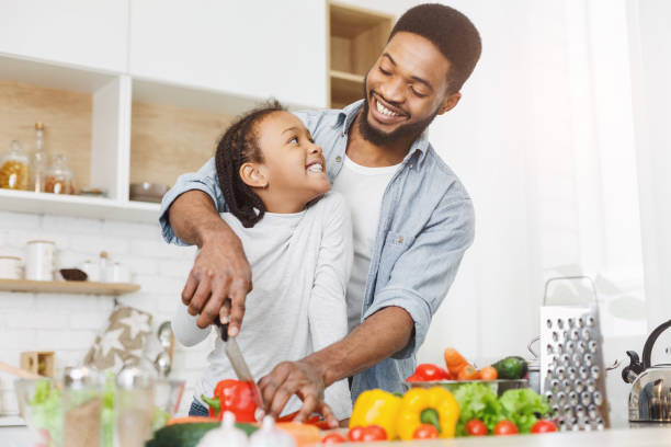 istock Dad teaching little girl how to cut vegetables 1173545187