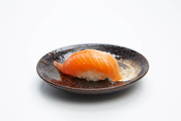 nahaufnahme von lachs nigiri sushi isoliert auf weißem hintergrund. - sake nigiri stock-fotos und bilder