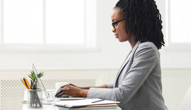 istock Black Office Girl Typing On Laptop Computer Sitting In Office 1173547953