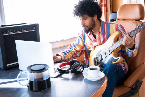 istock Digital Nomad young man guitar player in motorhome 1173548841