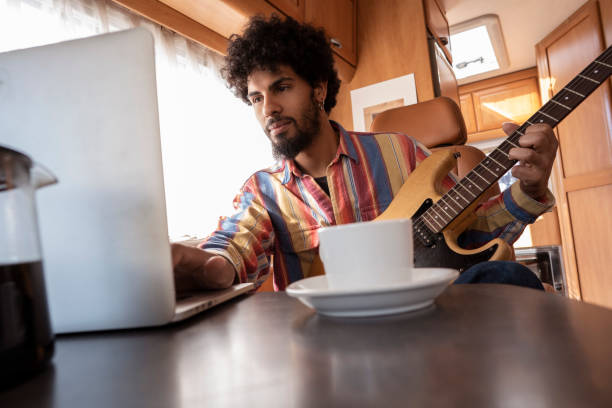 istock Digital Nomad young man guitar player in motorhome 1173549001