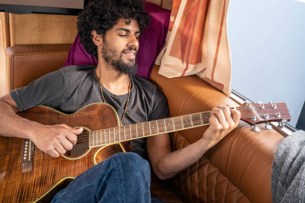 istock Ethnic nomad young man guitar player in motorhome 1173549086