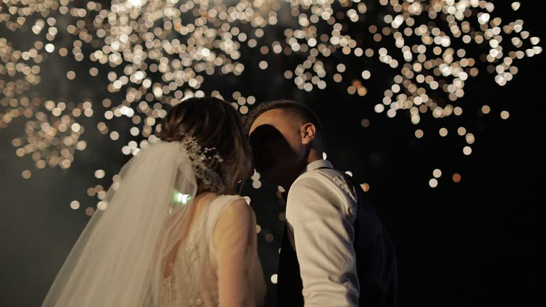 Couple in love watching fireworks. Silhouette newlyweds on fireworks background