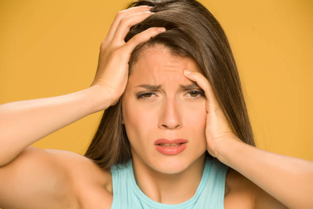istock Young woman with strong headache on yellow background 1173550244