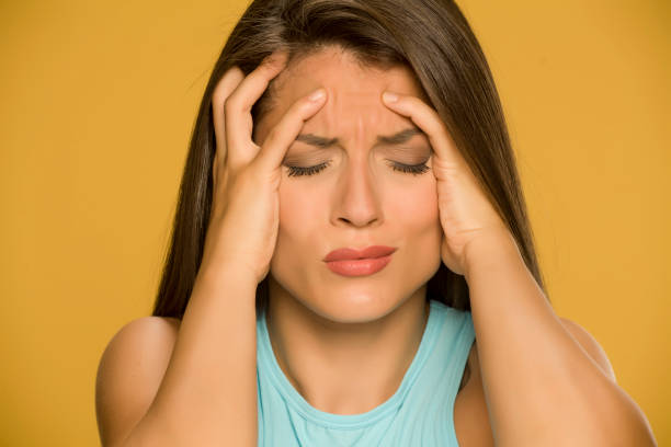 istock Young woman with strong headache on yellow background 1173550248