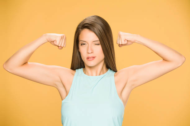 istock Young woman showing her hands on yellow background 1173550303