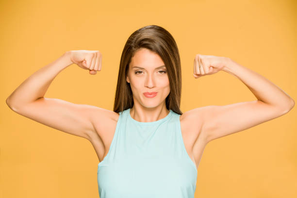 istock Young smiling woman showing her hands on yellow background 1173550310
