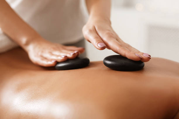 istock Masseur doing back hot stone massage, closeup 1173550720