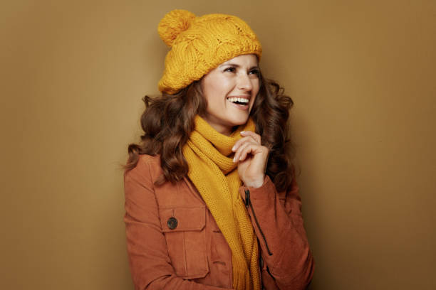 istock happy elegant woman looking aside isolated on beige 1173552558